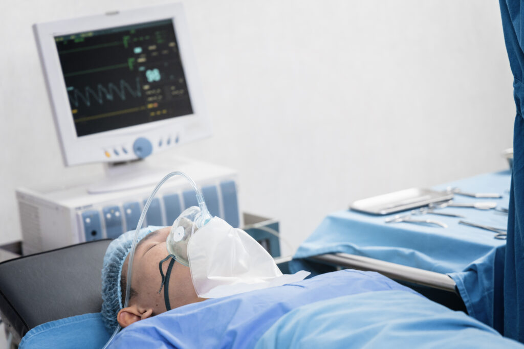 A patient wearing an oxygen mask in preparation for surgery