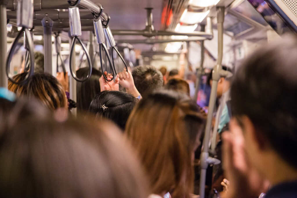 Passengers cram together and hold on to hand straps on the Bangkok sky train